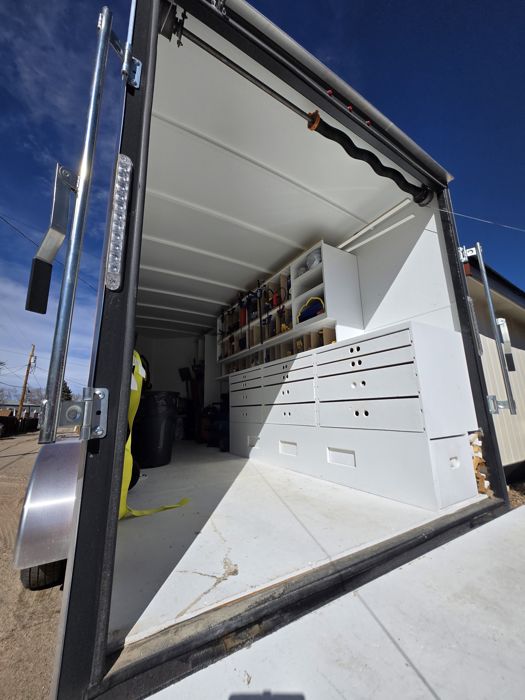 Custom cargo trailer build-out with white cabinets and drawers